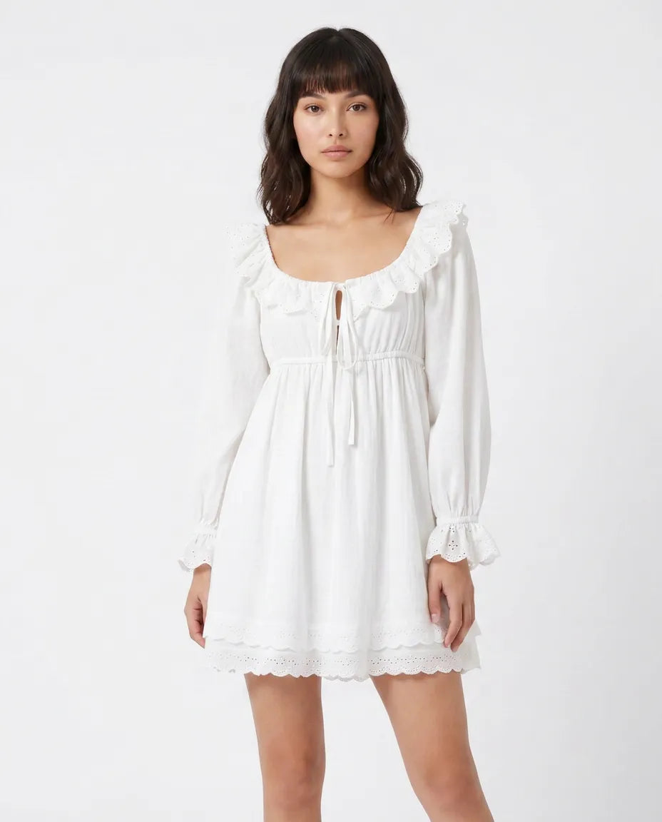 Model wearing the Elodie Ruffle Mini Dress in white