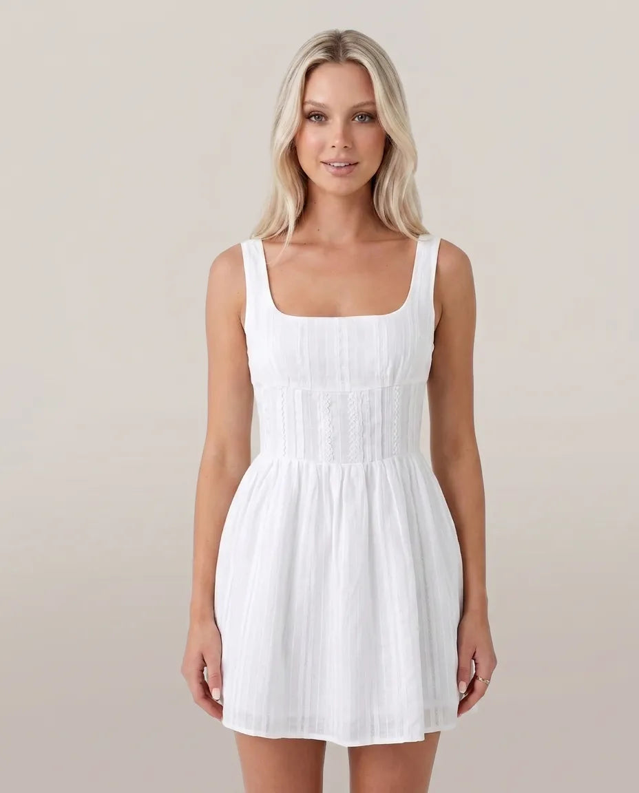 Front studio view of the blonde model wearing the white Amelie Mini Dress
